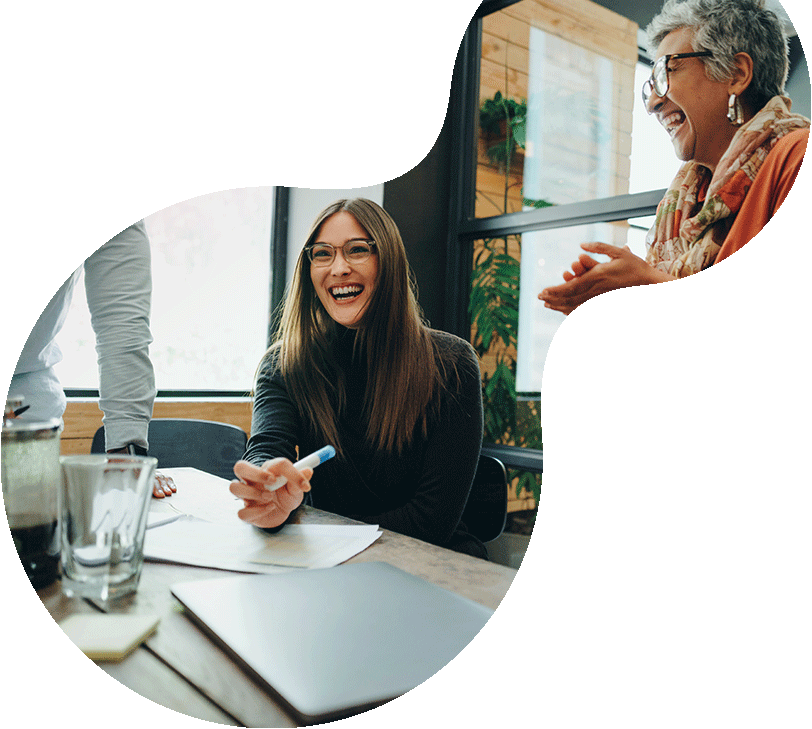 Master Data Management - Frauen sitzen in Meetingraum und lächeln